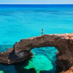 Woman on the beautiful natural rock arch near of Ayia Napa, Cavo Greco and Protaras on Cyprus island