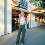 woman with shopping bag and ice cream in front of a store