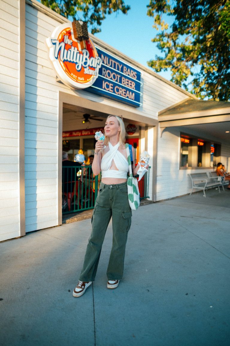 woman with shopping bag and ice cream in front of a store