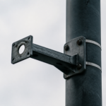 An empty camera mounting bracket on a street pole where a surveillance camera was removed