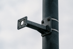 An empty camera mounting bracket on a street pole where a surveillance camera was removed