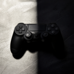 A game controller on a surface split between bright light and deep shadow